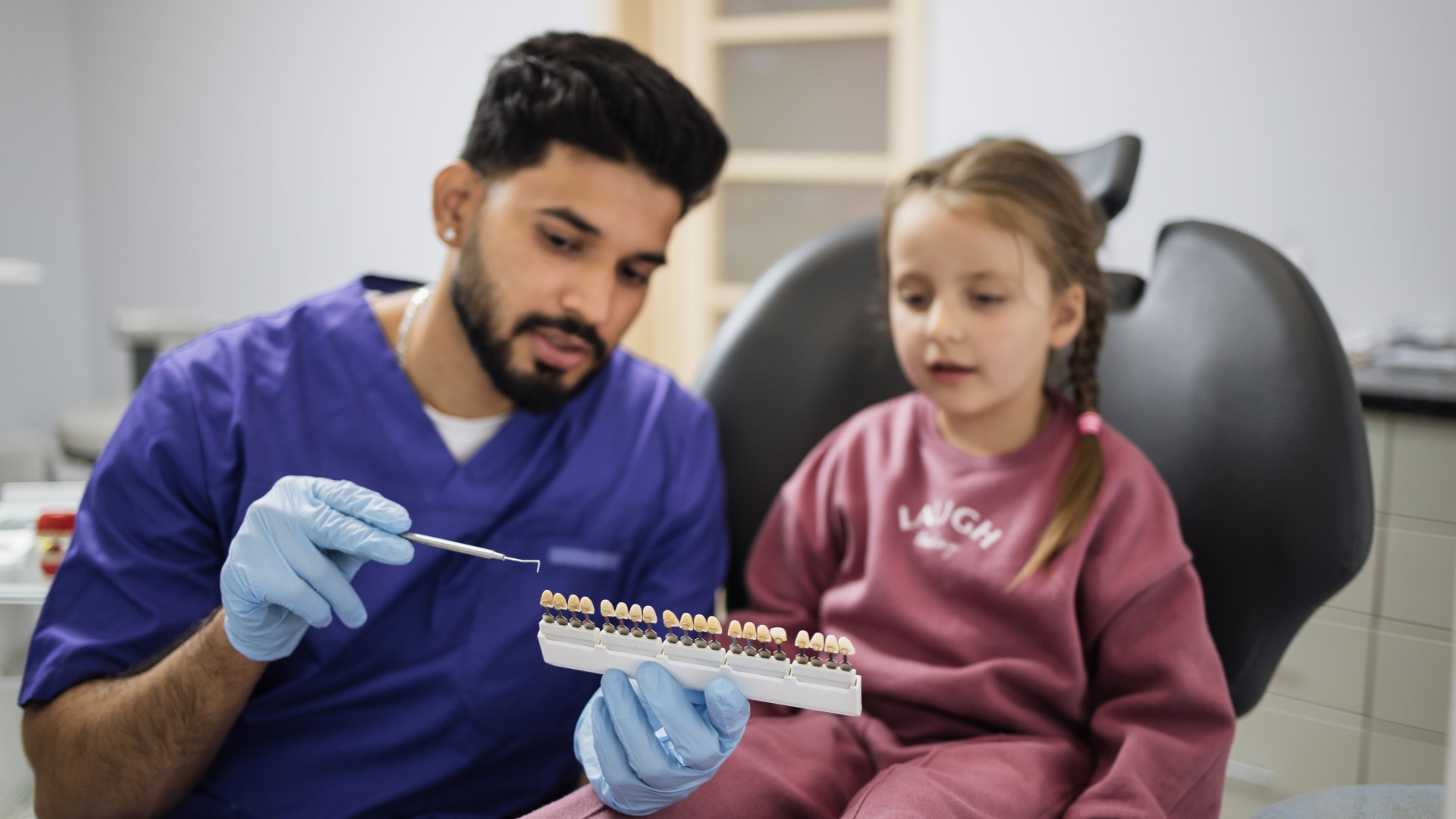 professional-male-dentist-choosing-color-of-fillin-2024-12-12-06-29-30-utc